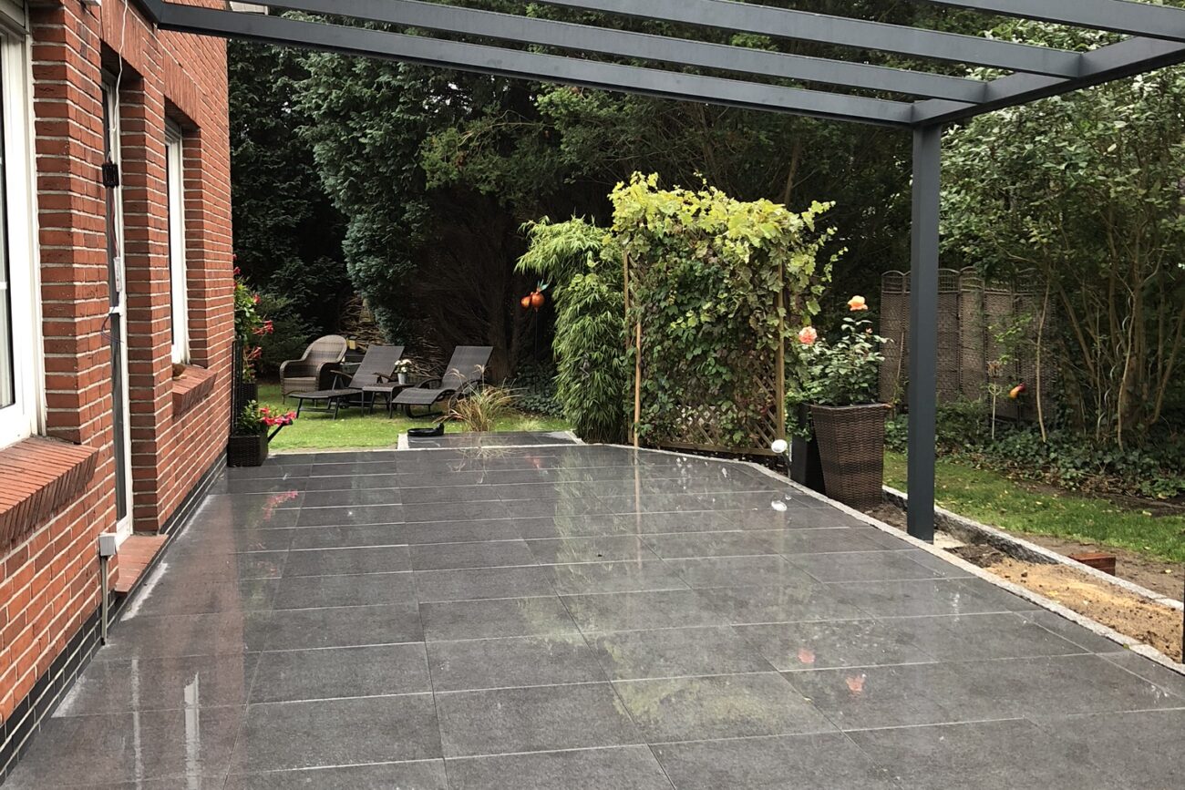 Grau gepflasterte Terrasse mit Überdachung