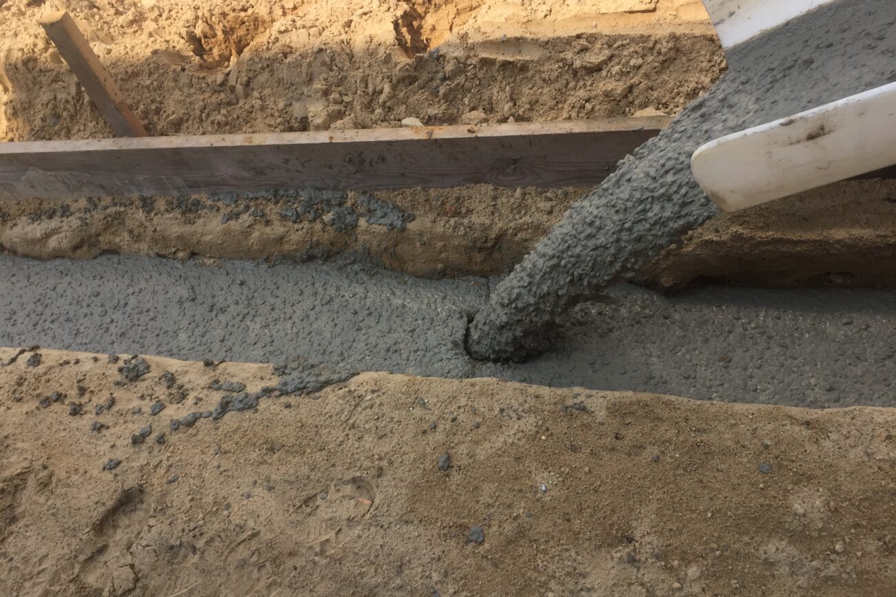 Zement wird in einen Drainageschacht gegossen