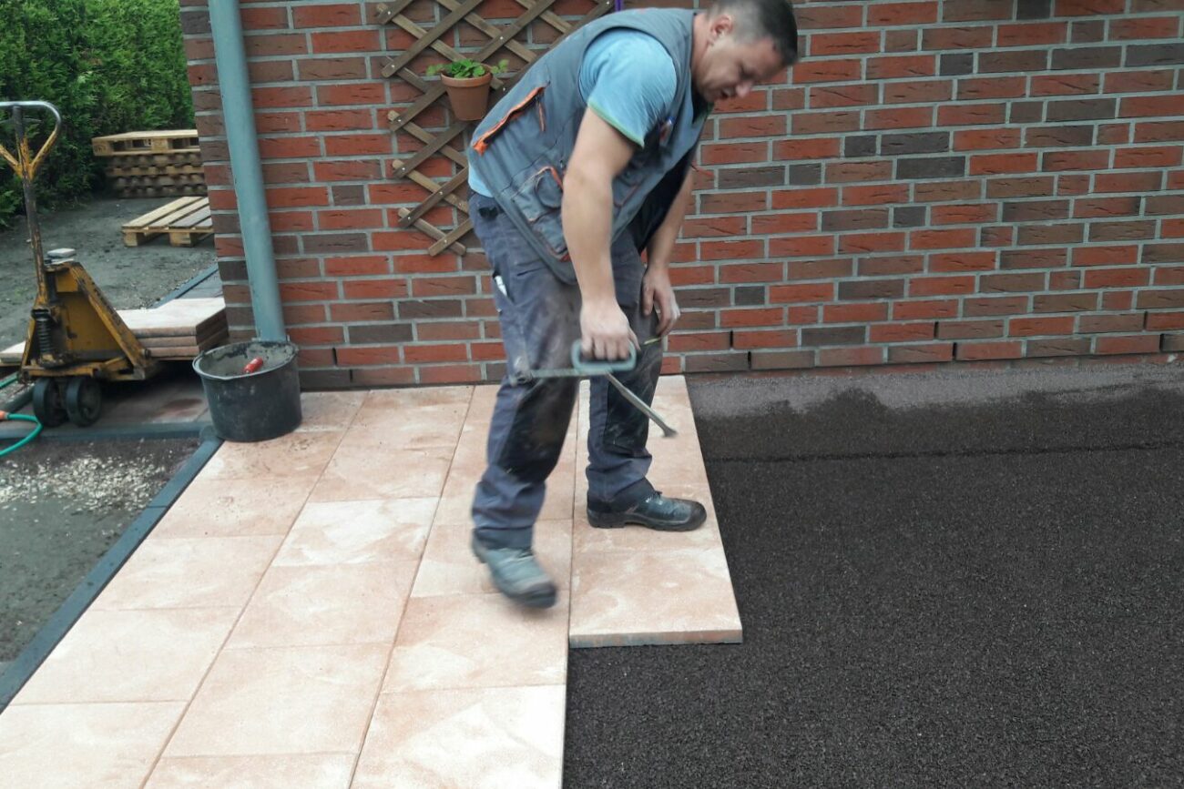 Handwerker beim Pflastern einer Terrasse