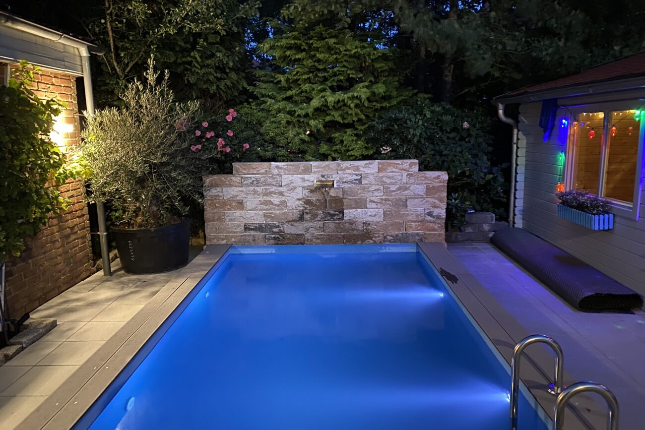 Ein beleuchteter Swimmingpool im Garten