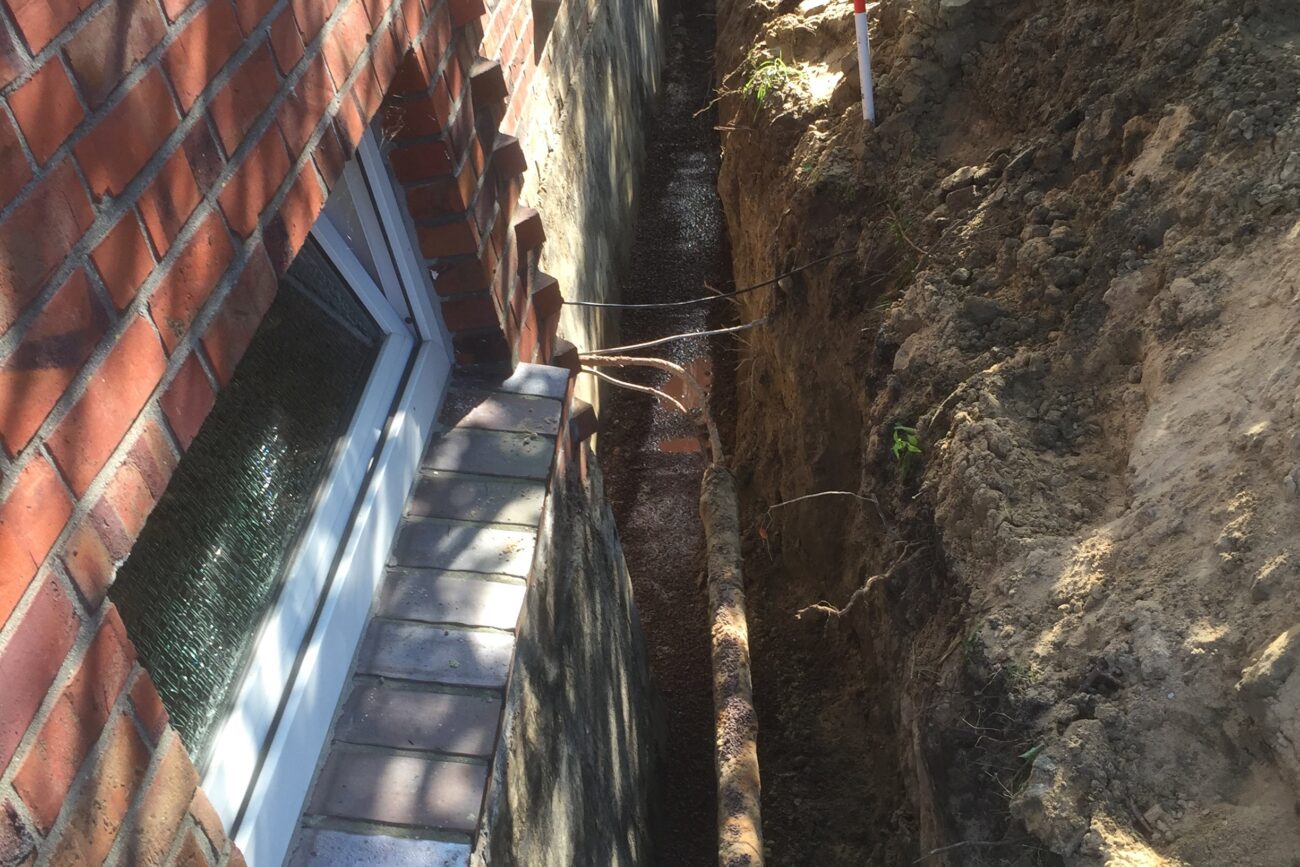 Baustelle wegen eines Wasserschadens an einem Kellerfenster